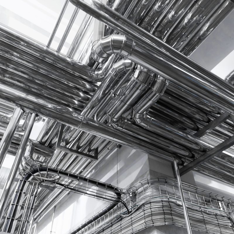 Modern brewery factory interior. pipe lines and other equipment tool in plant workshop. Industrial background. Metal pipes close-up. Industrial plant inside view. Maze of pipes background